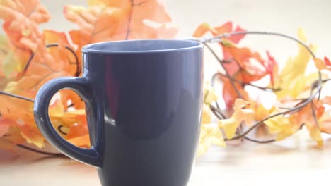 vapor saliendo de una taza de café o té con efecto bokeh y hojas doradas