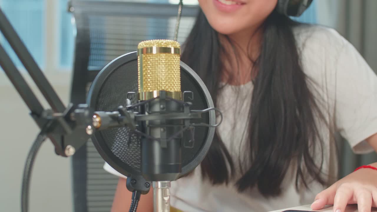 Asian Kid Girl Talking With Microphone During Online Livestream In Podcast Studio