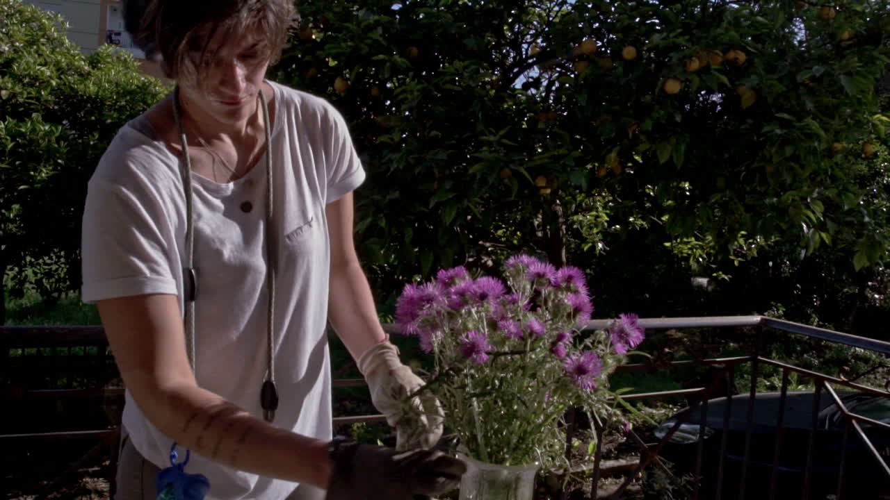 mujer decora un vaze con flores silvestres en el porche de una casa de campo 60fps