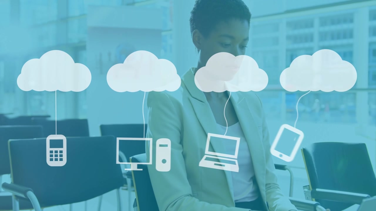 Animation of clouds with icons over business people using laptop