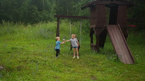 little girl gives bouquet to younger brother on playground