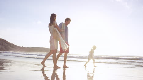 Glückliche-Familie,-Die-Bei-Sonnenuntergang-Im-Urlaub-In-Den-Wellen-Am-Strand-Spielt