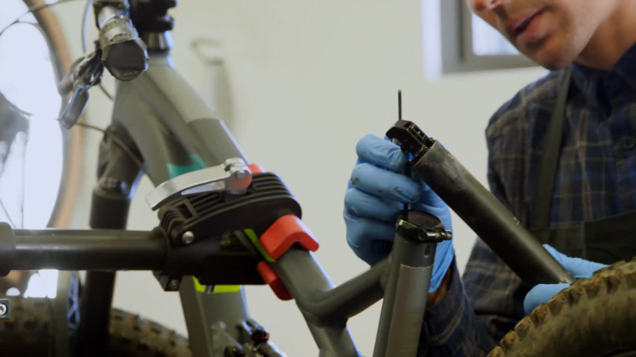 hombre reparando una bicicleta en el taller 4k