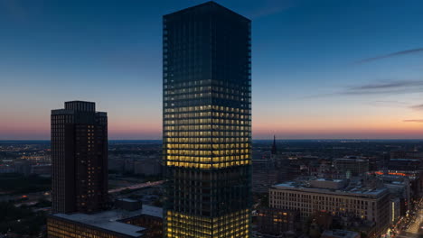 modern skyscraper lighting up at dusk