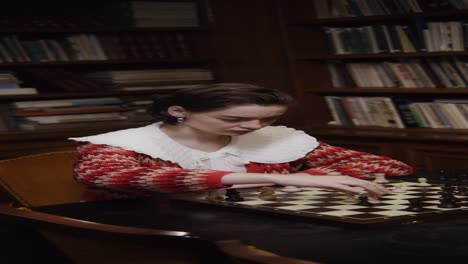 mujer jugando al ajedrez en una biblioteca