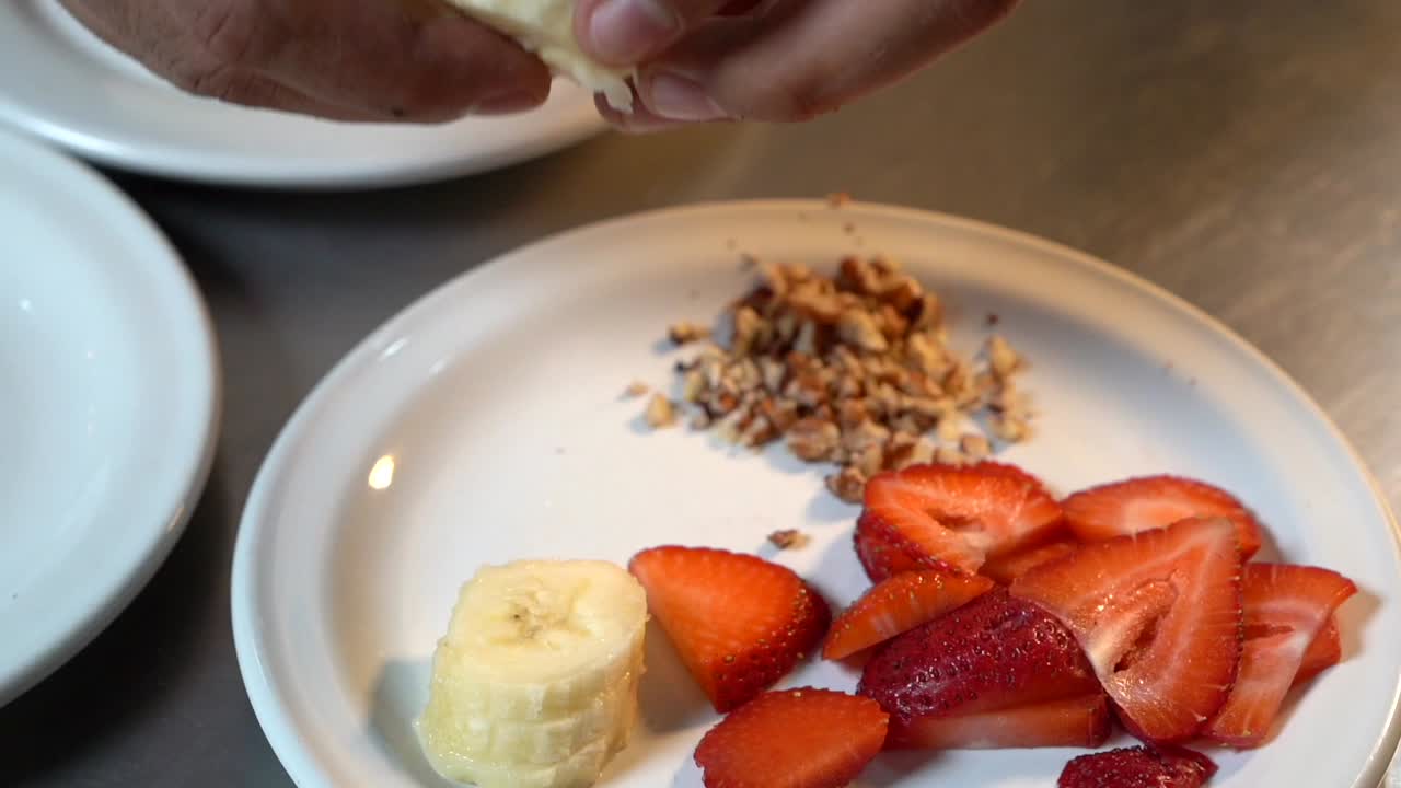 상단 헤이즐넛 크림 베이글 토스트에 신선한 바나나 조각을 추가하는 요리사