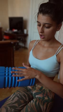 woman using a foam roller for self-massage at home