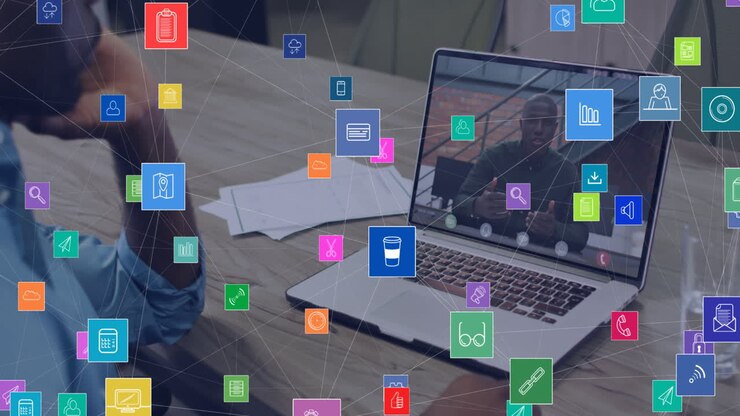 Animation of network of connections with icons over african american businessman on laptop