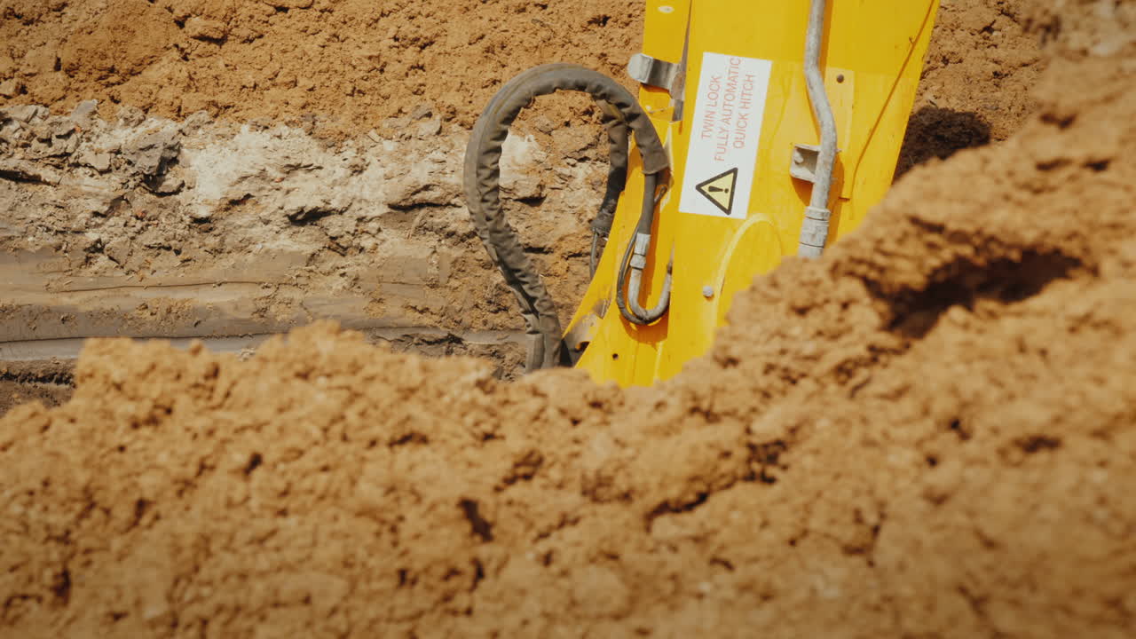 cucharón de excavadora extrae tierra de una zanja profunda
