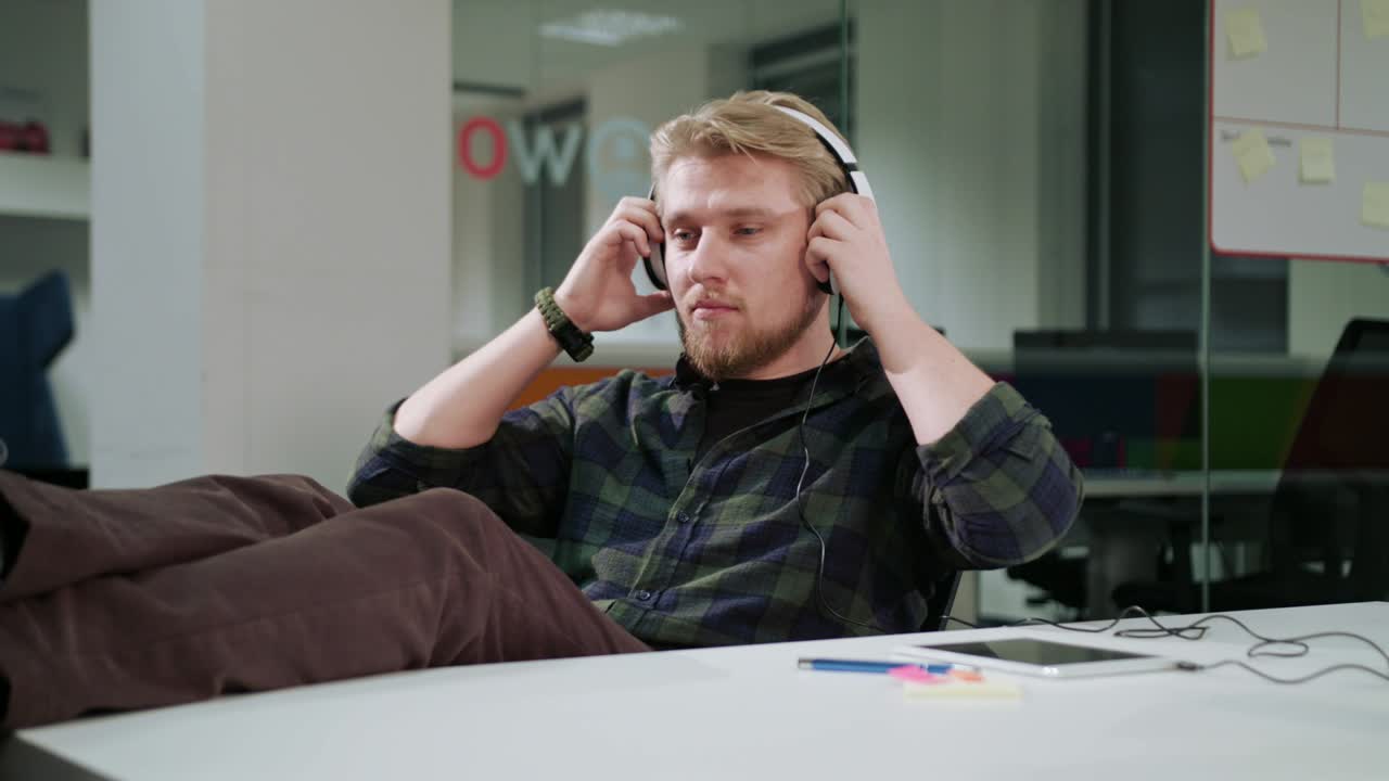 태블릿 을 사용 하고 음악 을 듣고 있는 젊은 남자