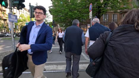 pedestrians crossing a busy street in milan