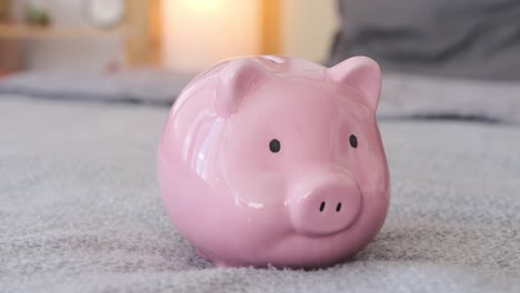 boy inserting coin into piggy bank