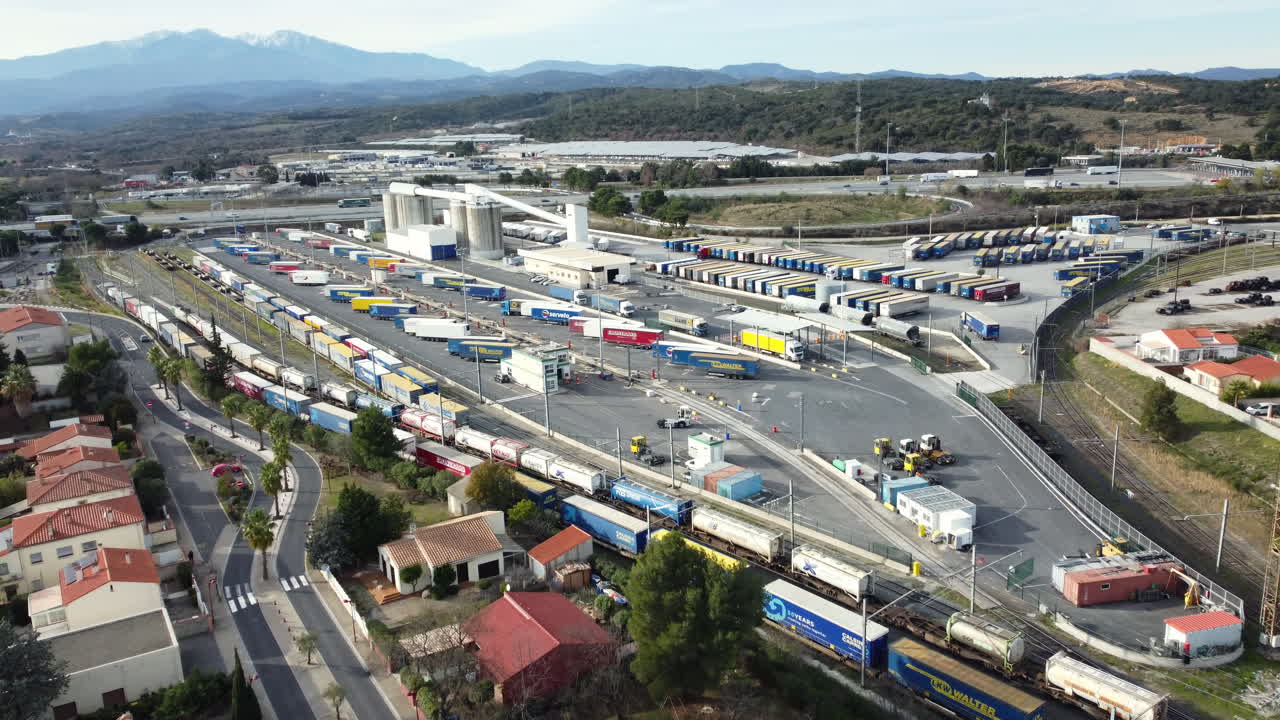 Aerial View of a Freight Terminal with Trains and Trucks