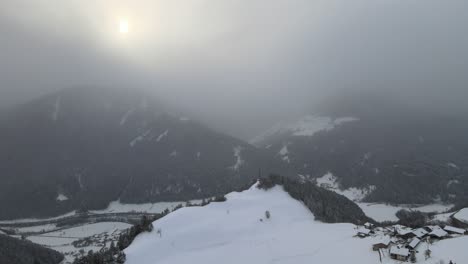 Tormenta-De-Nieve-De-Mal-Humor-Oscuro-En-Los-Alpes-Italianos,-Puedes-Ver-Un-Valle-Frío-Y-Un-Pueblo