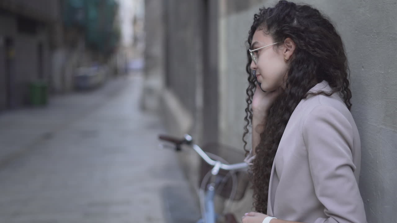 Young Woman Leaning Against a Wall in a City Street