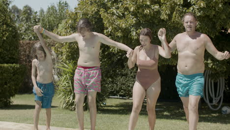 padres alegres y niños tomándose de la mano y corriendo juntos a las piscinas