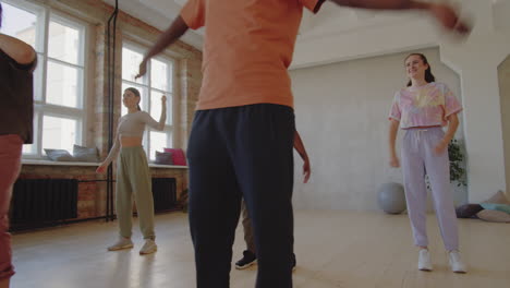 multiethnic people learning dance with teacher in studio