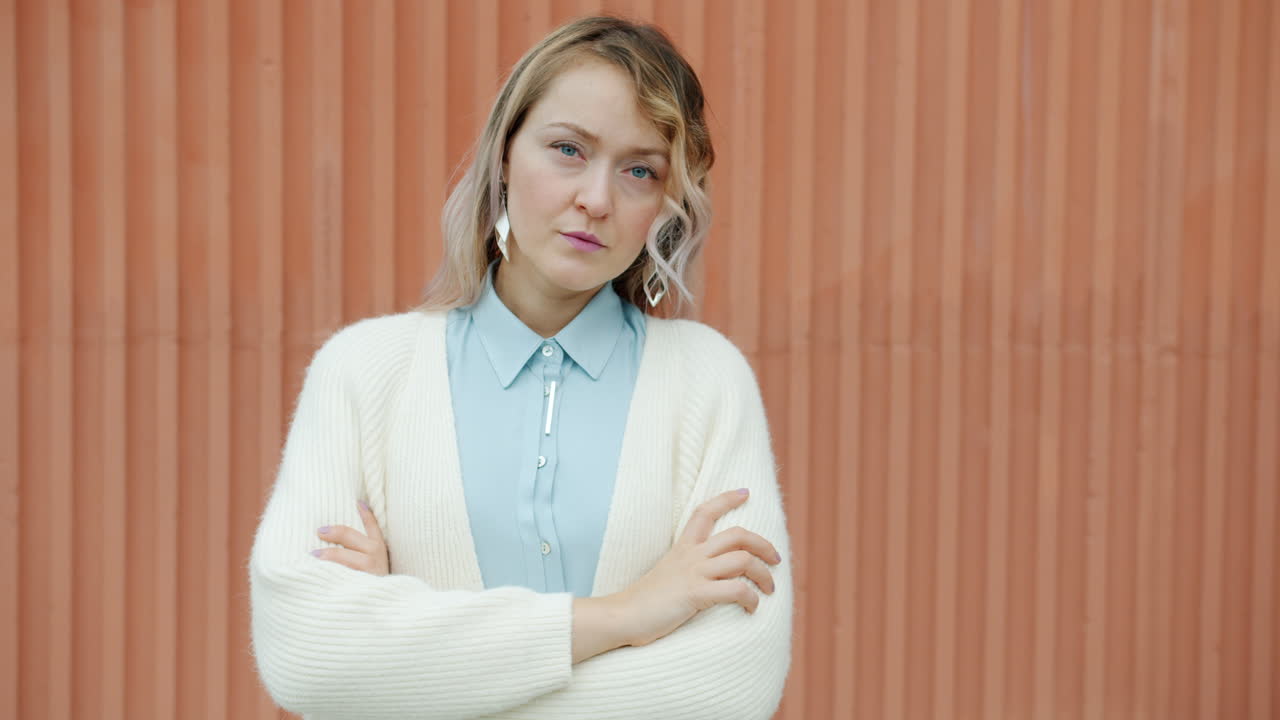 Woman in cream cardigan and light blue shirt