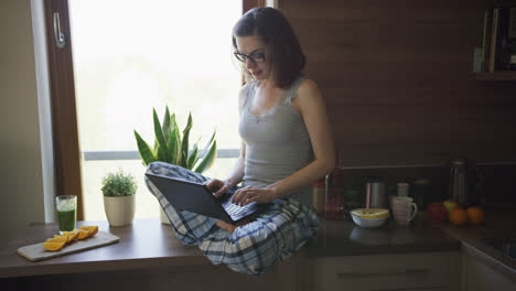 Attractive-woman-sitting-on-table-using-laptop