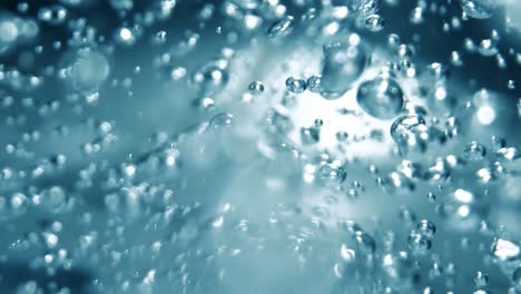 Many-water-bubbles-in-blue-water-close-up,-abstract-water-wave-with-bubbles-in-slow-motion.