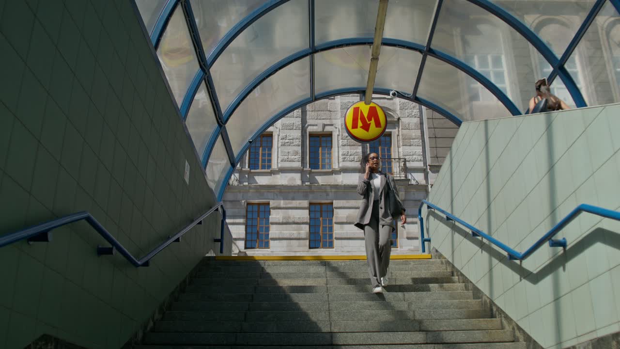 mujer caminando por las escaleras en una estación de metro