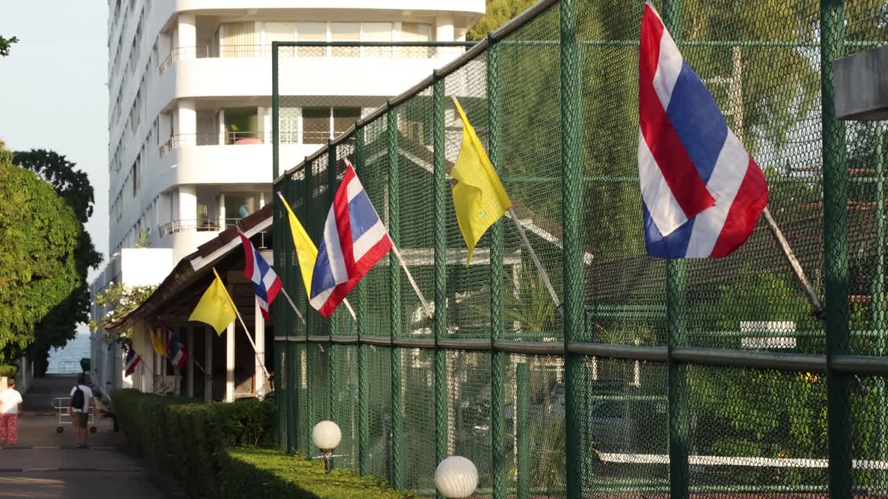 красочные флаги, развевающиеся над солнечным теннисным кортом