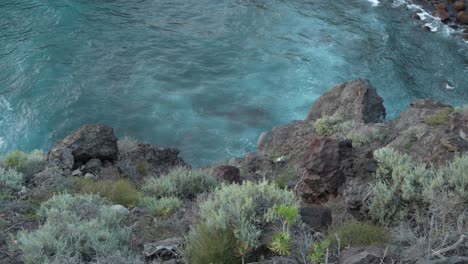 POV-shot-of-standing-at-the-edge-of-the-cliff-while-staring-at-the-waves-of-water-below,-static