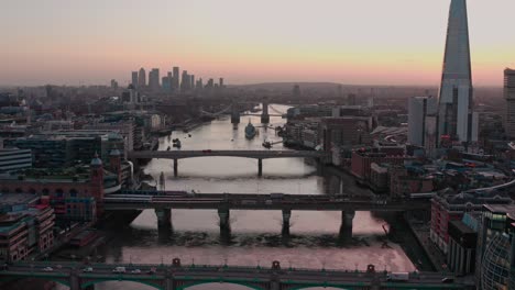 dolly forward aerial of bridges over thames river central london early morning sunrise