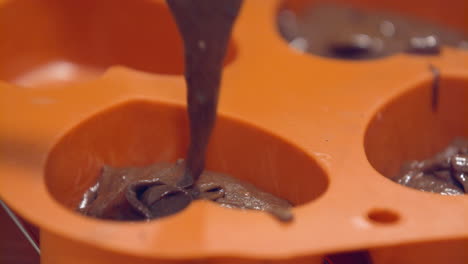 putting chocolate mix into heart shaped molds for baking and creating petit gâteau - slow motion
