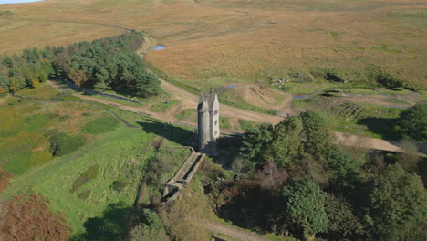 Lonely-stone-tower-on-hillside-in-autumn,-slow-orbit