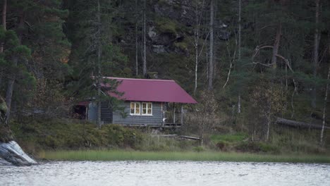 Hildremsvatnet,-Condado-De-Trondelag,-Noruega---Una-Cabaña-De-Pescadores-Junto-A-La-Orilla-Del-Lago---Plano-Amplio