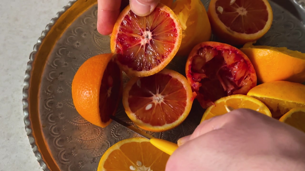 Hand cut orange fruit make fresh tasty juice organic healthy breakfast slice citrus homemade vitamin delicious refreshing pulpy wellness sweet winter Persian kitchen platter knife tabletop preparation
