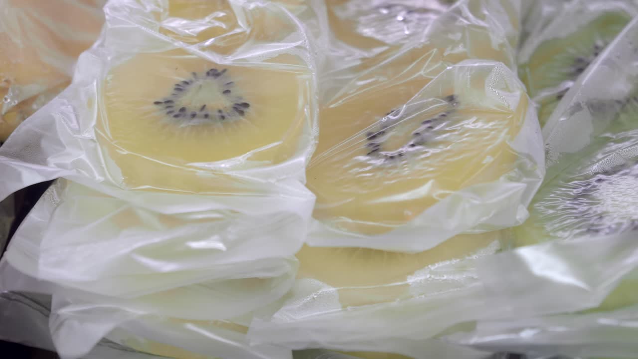 プラスチック包装に入った新鮮なスライスゴールデンキウイとグリーンキウイ
