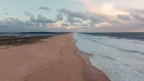 drone shot over sandy beach with big ocean waves