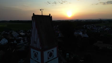 the colours of golden hour highlight the outline of a church silhouette