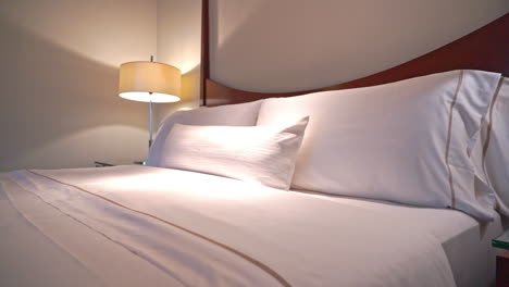 tilt-down from headboard along the center of a made-up hotel suite bed