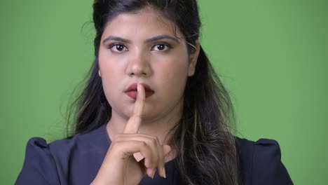 joven sobrepeso hermosa mujer de negocios india contra fondo verde