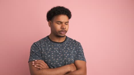 disagreeing young man shaking head in pink studio