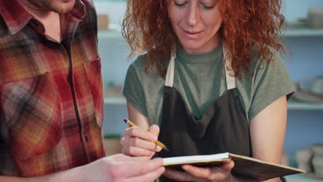 couple discussing pottery design in a workshop