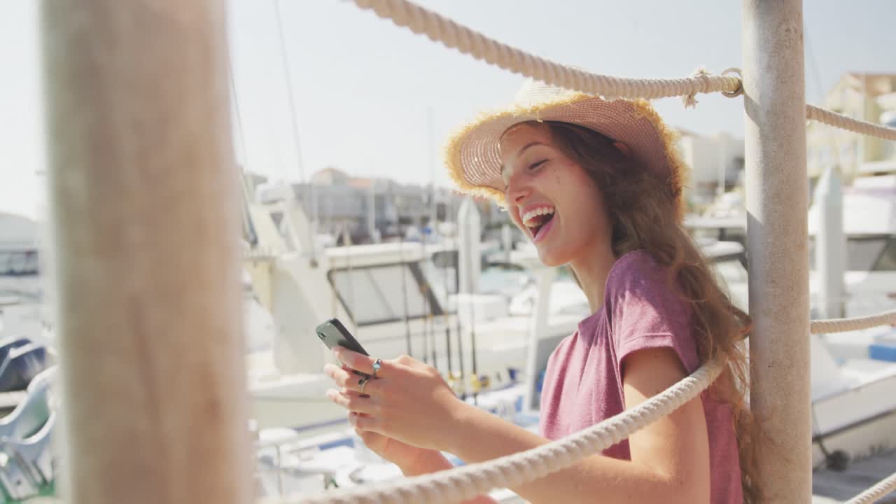 십대 백인 소녀 가 전화 하버 사이드 를 사용 하고 있는 측면 보기