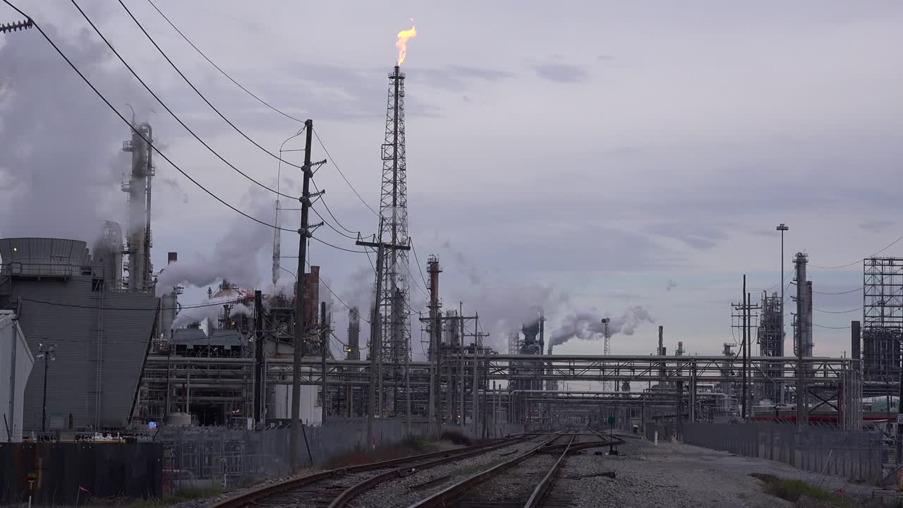 una enorme refinería de petróleo emite humo y fuego al cielo 1