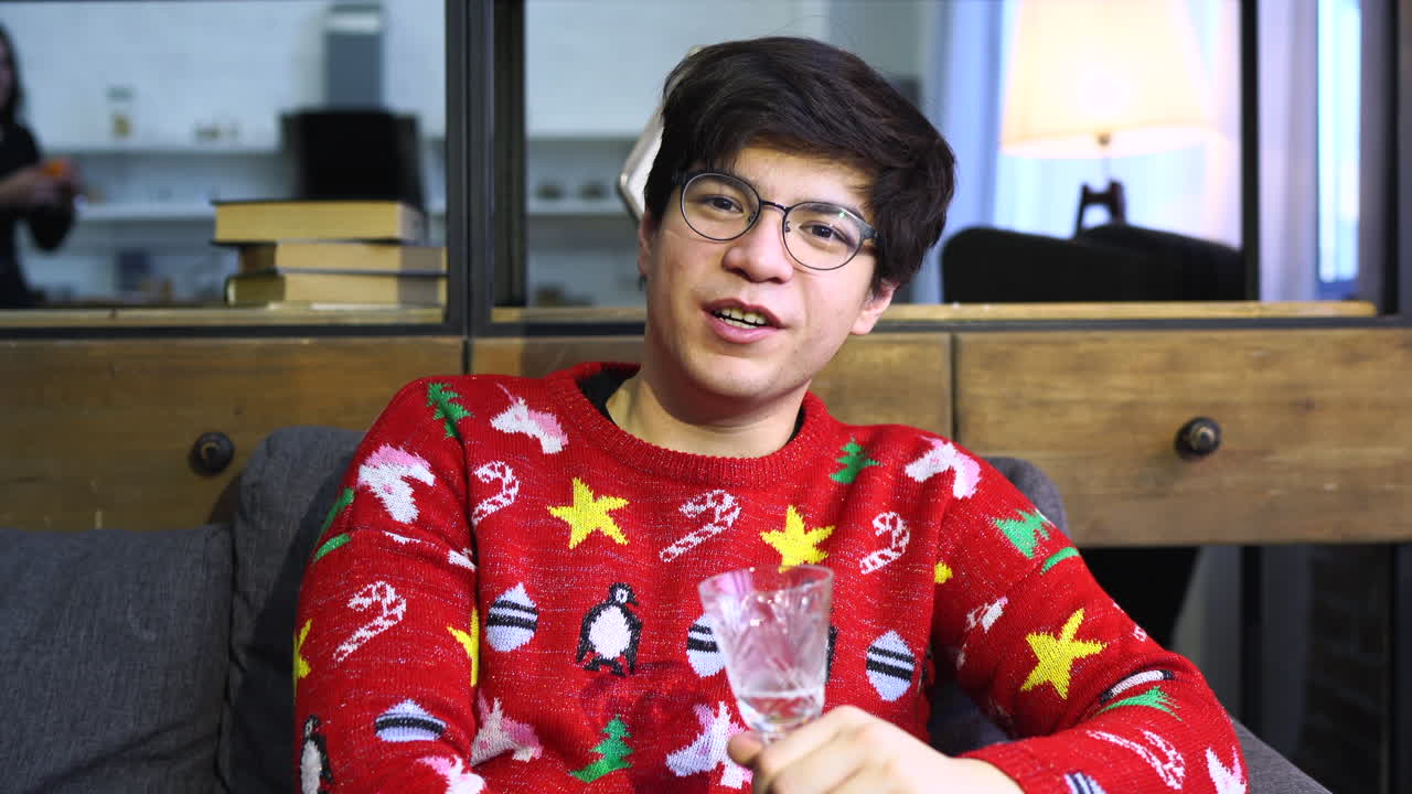 음료와 함께 크리스마스 스웨터를 입은 남자