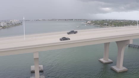 porsche 911 carrera drives on bridge in st pete beach, florida, usa, aerial view