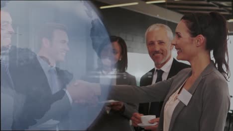 Animation-of-globe-icon-over-caucasian-businessman-and-businesswoman-shaking-hands-at-office