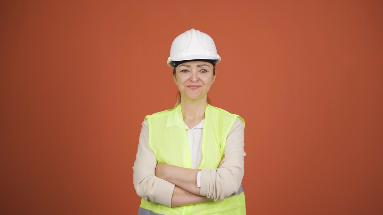 la ingeniera cruza los brazos y se ríe de la cámara.