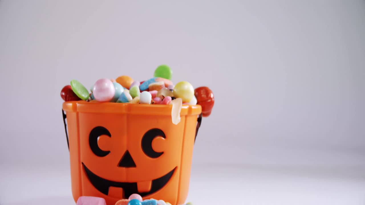 Halloween bucket filled up with various confectioneries 4k