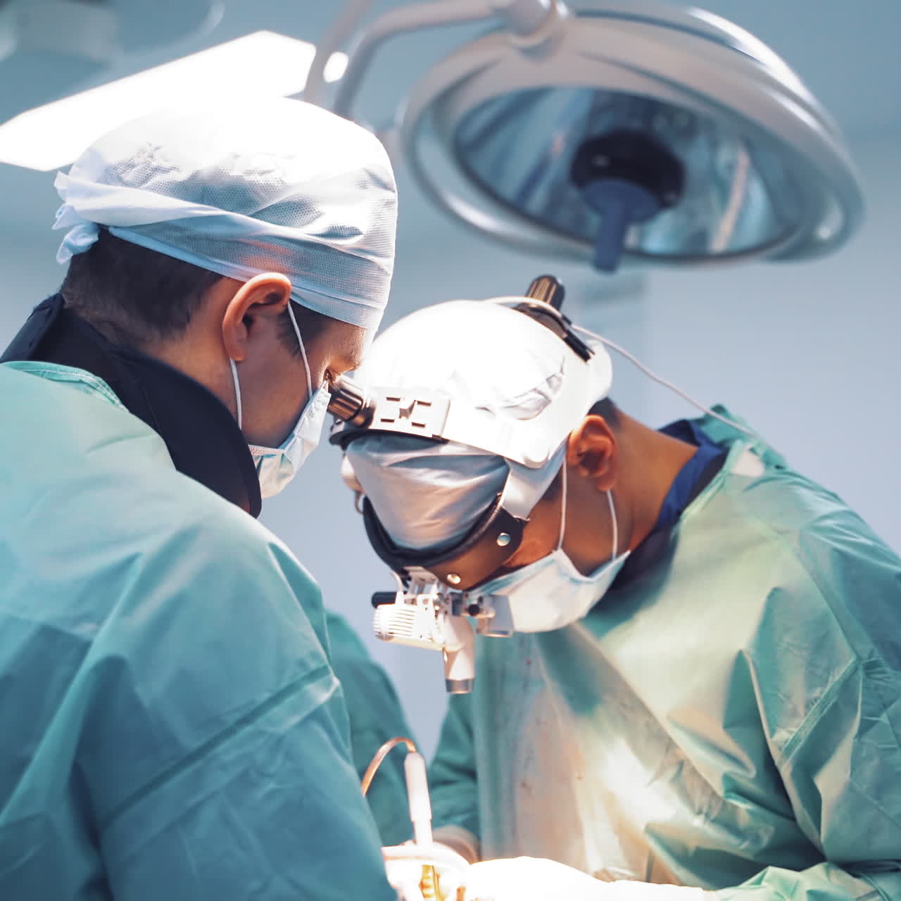 Operating process by specialists in medical masks in clinic. Professional surgeon with male assistants performing an operation to a patient. Close-up.