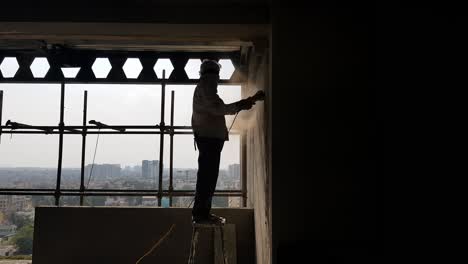 un trabajador de la construcción que trabaja sin equipo de seguridad en condiciones peligrosas en india