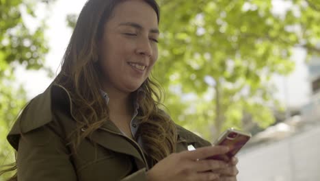 smiling young woman holding modern smartphone outdoor