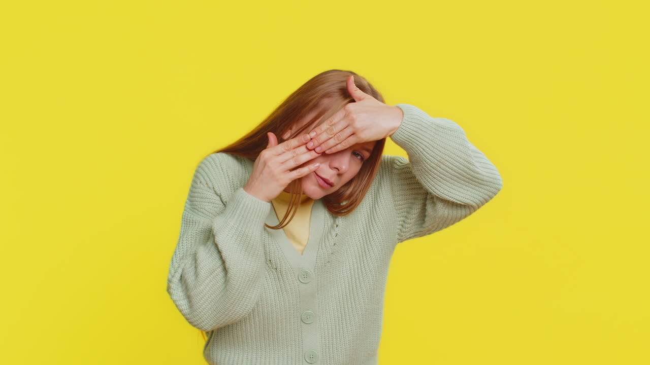 호기심 많은 성숙한 여성은 손으로 눈을 감고 손가락을 통해 스파이를 숨기고 보는